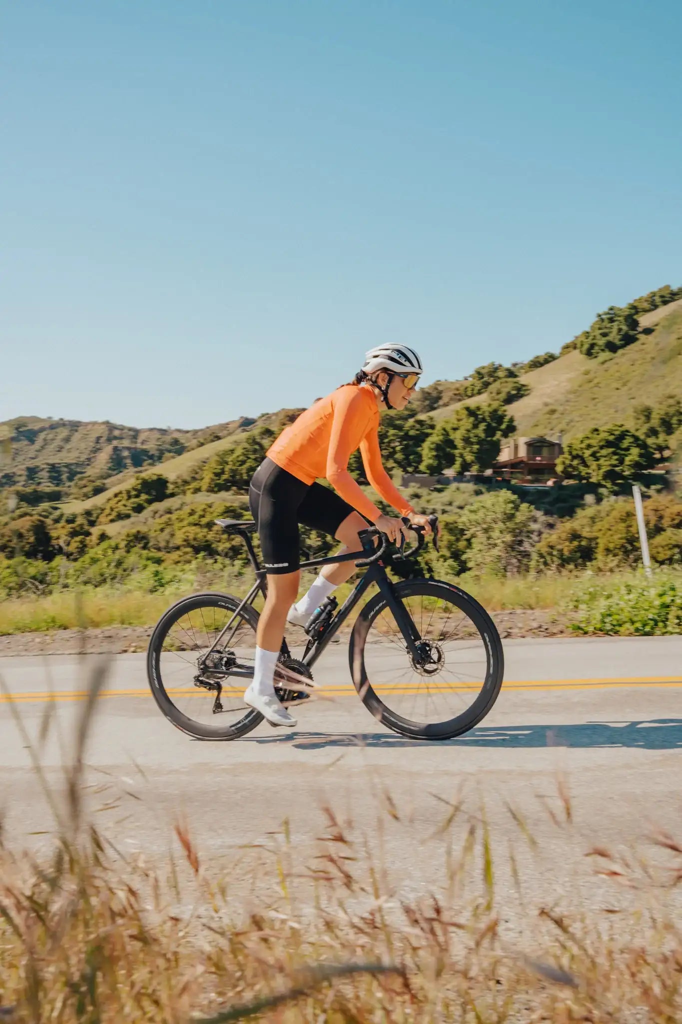 Cyclist riding a road bike on a scenic hillside road